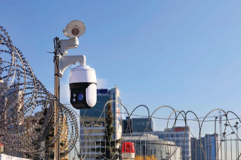 AI-enabled CCTV camera securing a perimeter with a city skyline